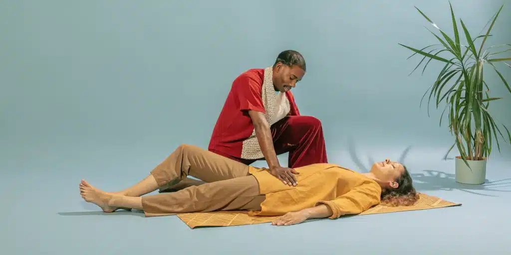 A woman receives an assisted stretch from a professional to release chronically tight muscles.
