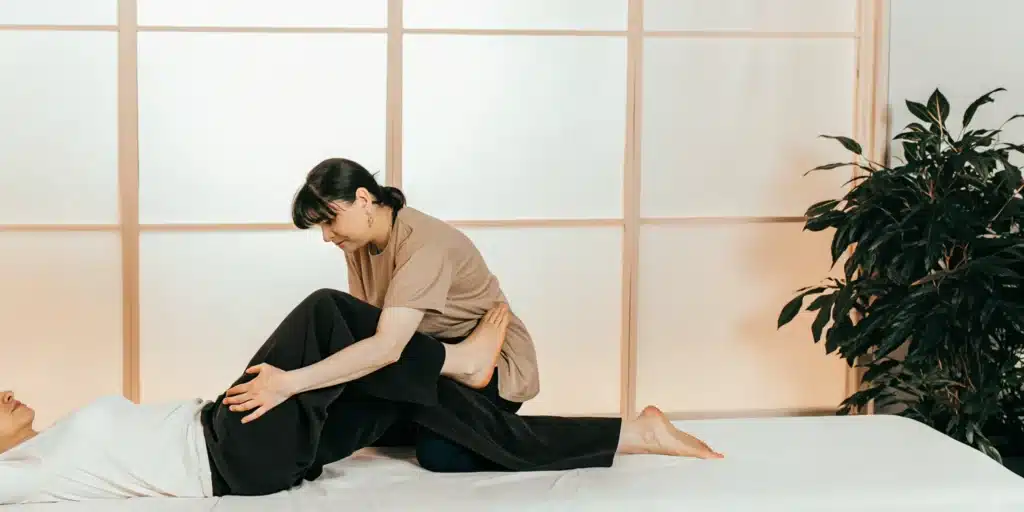 Fascia stretch therapy session with a therapist assisting a client on a treatment table.