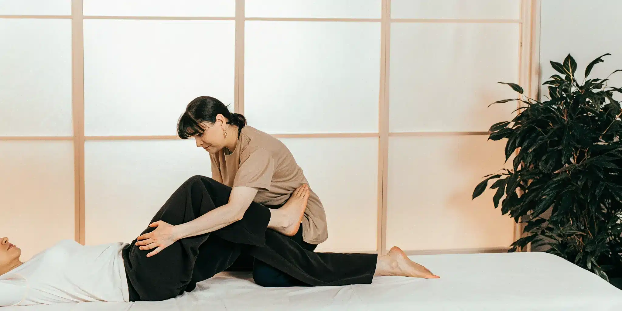Fascia stretch therapy session with a therapist assisting a client on a treatment table.