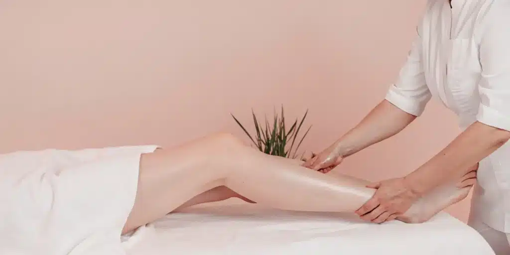 A therapist performs a passive range of motion exercise on a patient's leg to improve mobility.