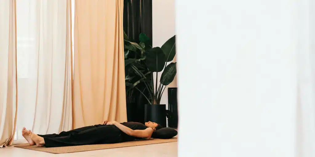 A person on a mat performing a PNF stretching technique for increased flexibility.