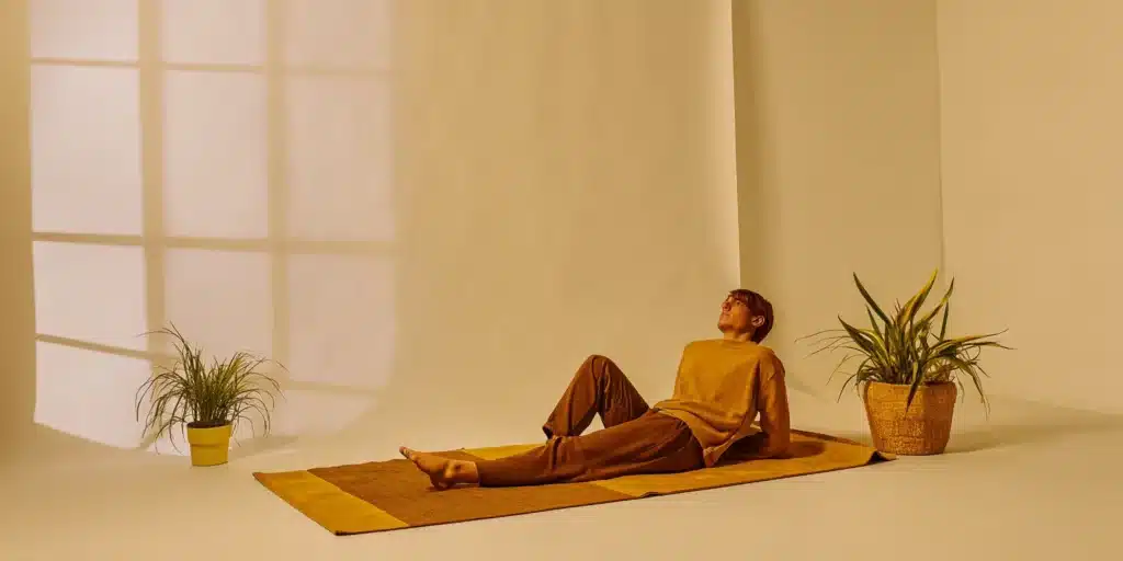 A person performing a stretch on a mat to improve flexibility.