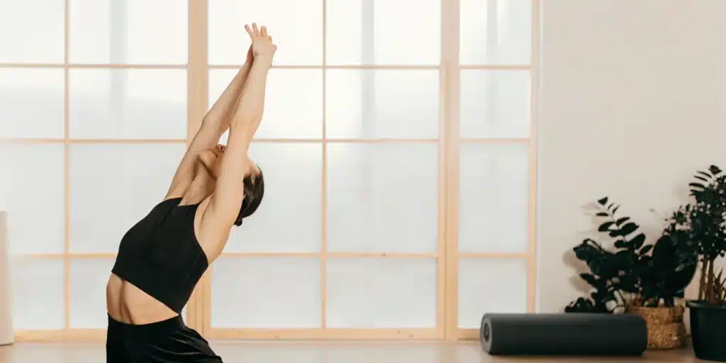 Woman relieving body stiffness with a gentle standing stretch.