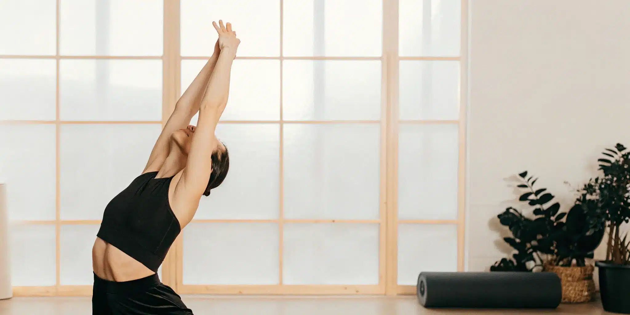Woman relieving body stiffness with a gentle standing stretch.