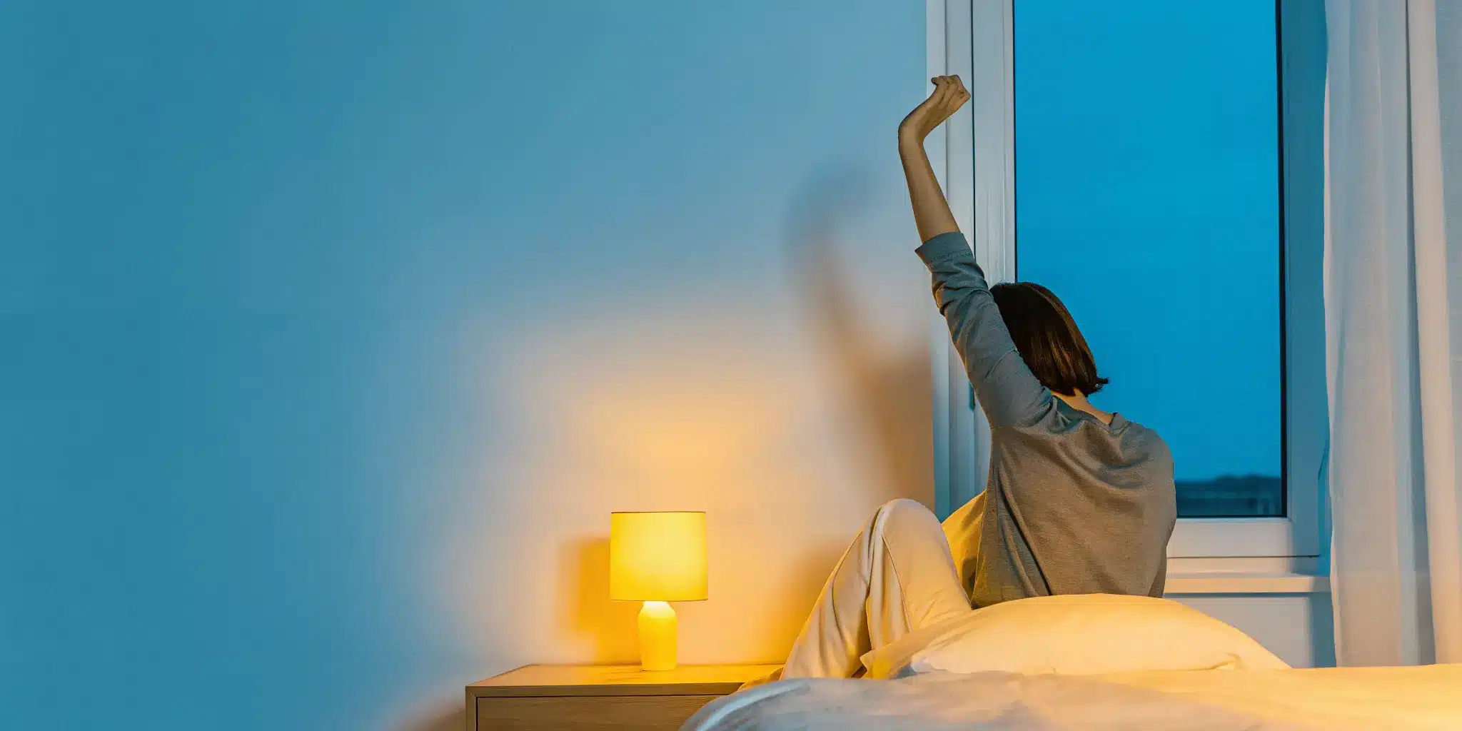 Woman in bed holding her shoulder, experiencing joint pain at night.