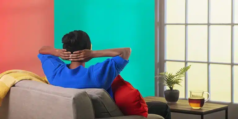 Woman at home relieving neck and shoulder muscle tightness with a gentle stretch.