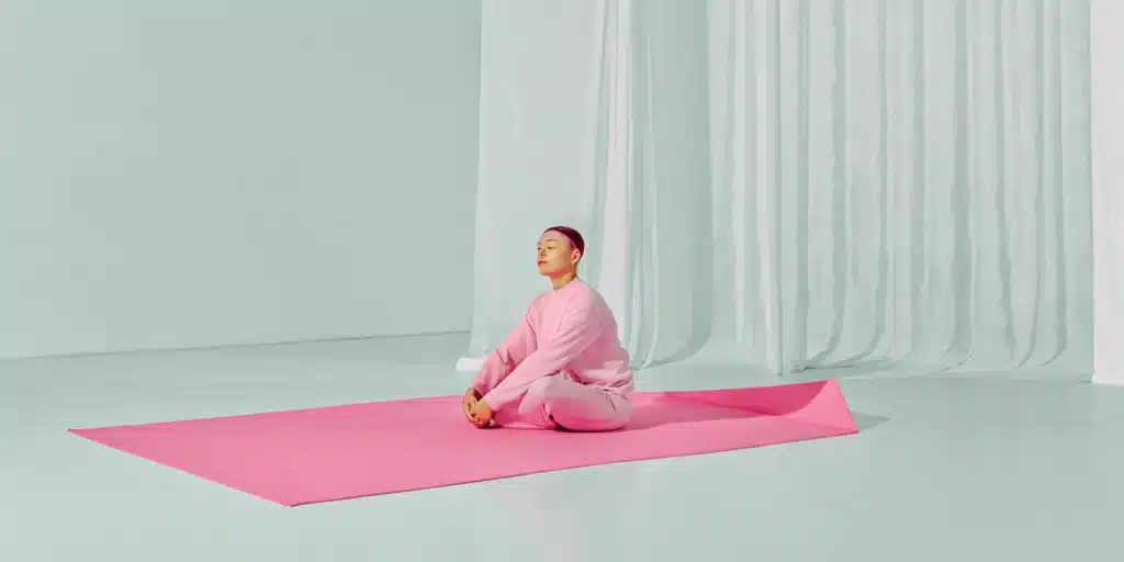 Woman in a seated yoga pose, a solution for what causes tight muscles all over the body.