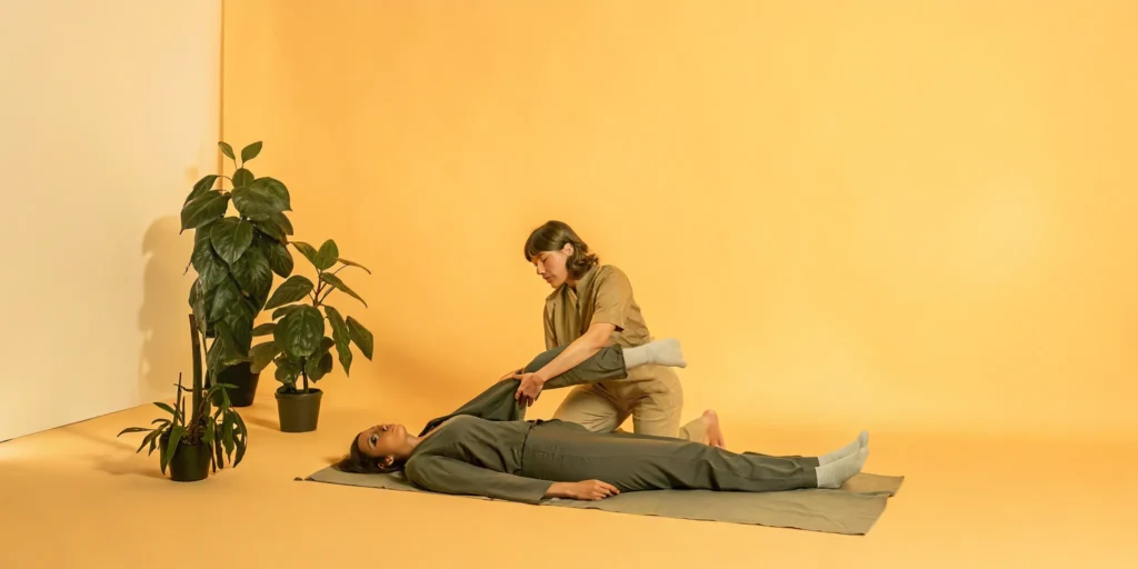 A therapist provides assisted stretching to a client in a studio for improved flexibility.