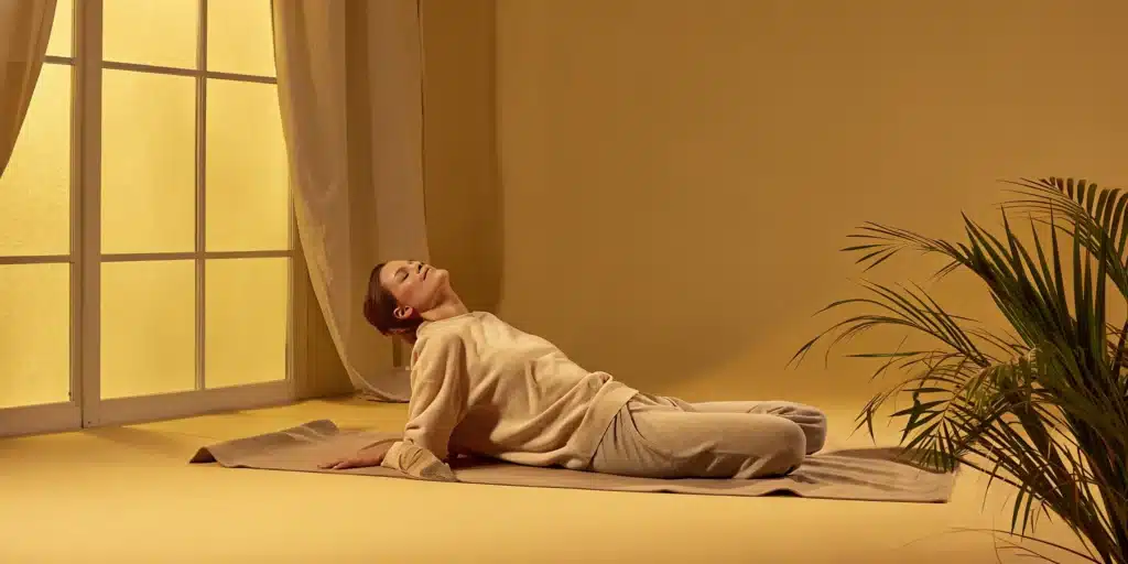 Woman doing a gentle stretch on a yoga mat to relieve whole body stiffness.