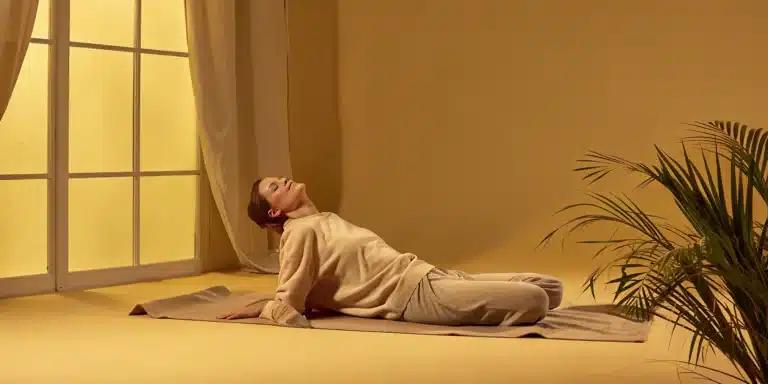 Woman doing a gentle stretch on a yoga mat to relieve whole body stiffness.
